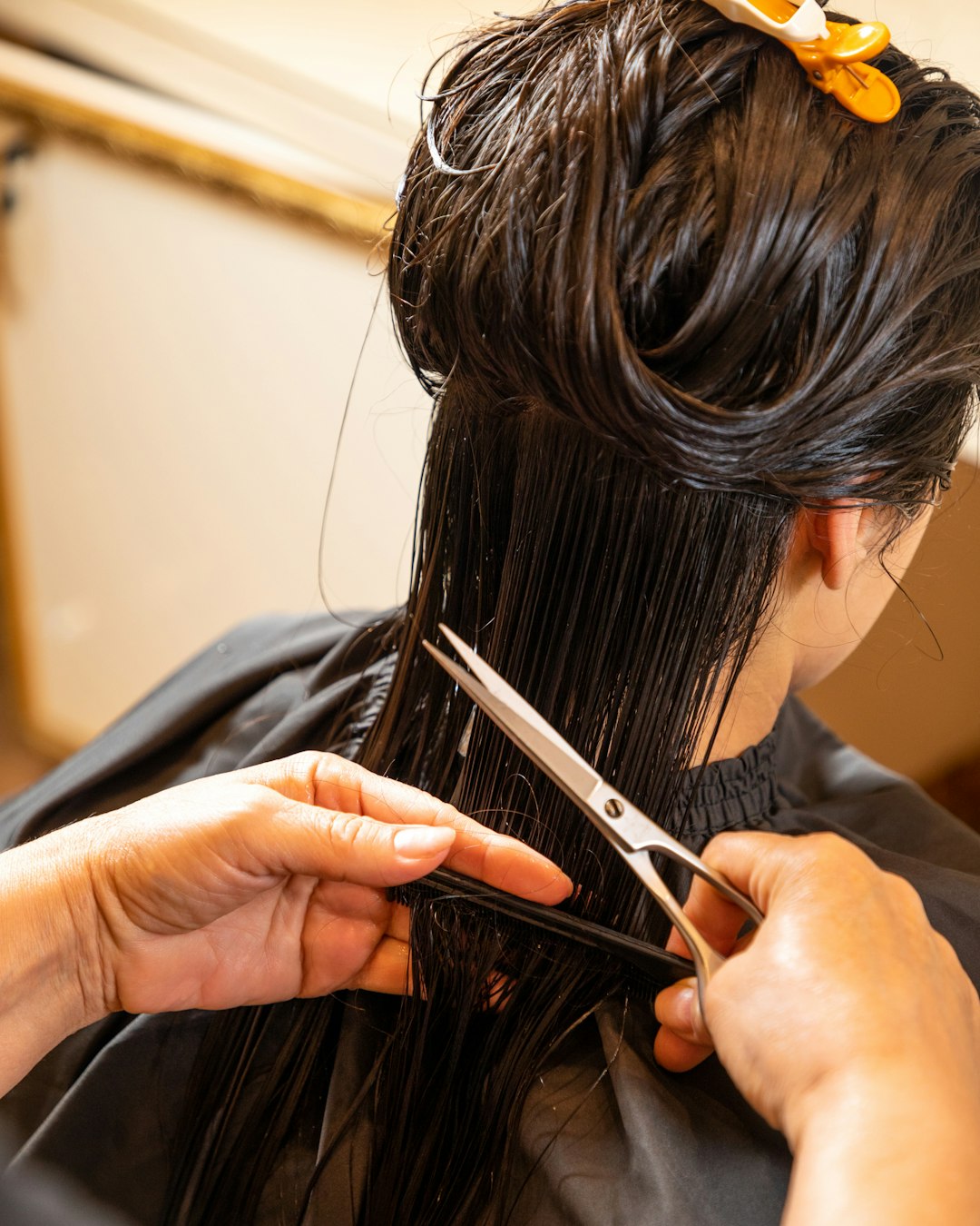Coiffeuse qui coupe les cheveux d’une cliente aux ciseaux