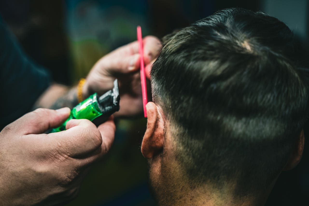Coiffeuse en train de couper les cheveux d’une cliente, vue de dos