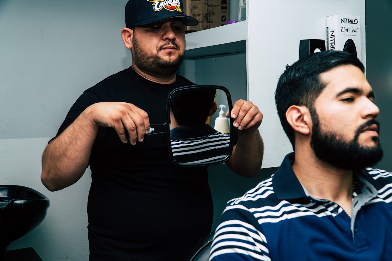 Le coiffeur présente le résultat au client avec un miroir